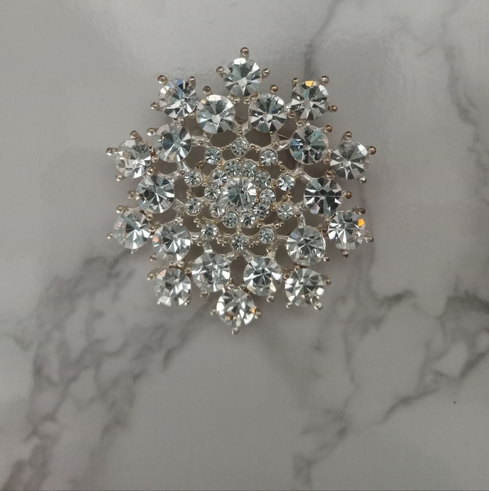 Decorative starburst or snowflake crystal brooch or pin